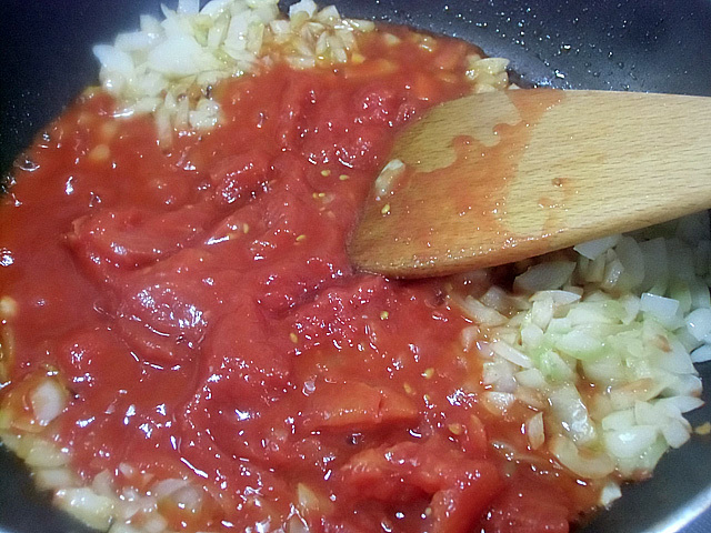 炒めたタマネギにトマトの缶詰